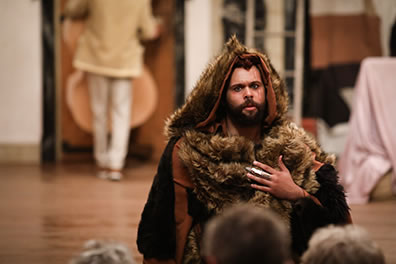 Production photo by Lindsey Walters of The Bear with silver claw talking to the audience